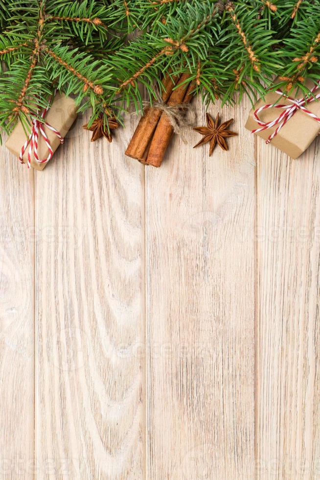 fondo de navidad con abeto y caja de regalo en la mesa de madera. vista superior con espacio de copia para su diseño foto