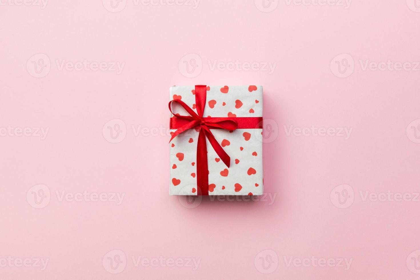 Background with gift box and hearts on rose Background. Top view with copy space for text photo