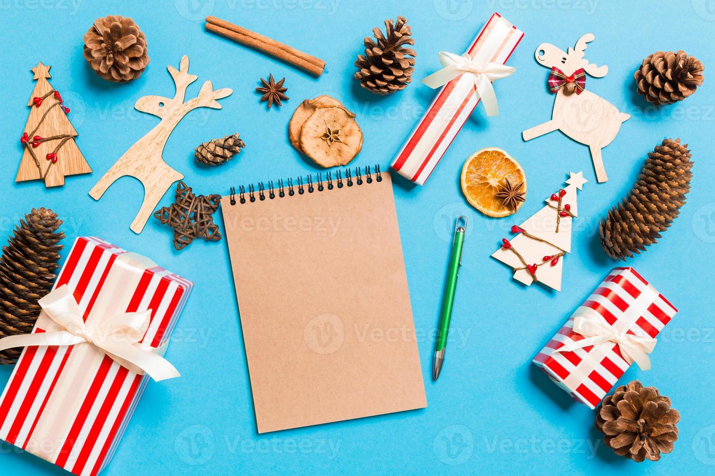Top view of notebook on blue background made of Christmas decorations. New Year time concept photo
