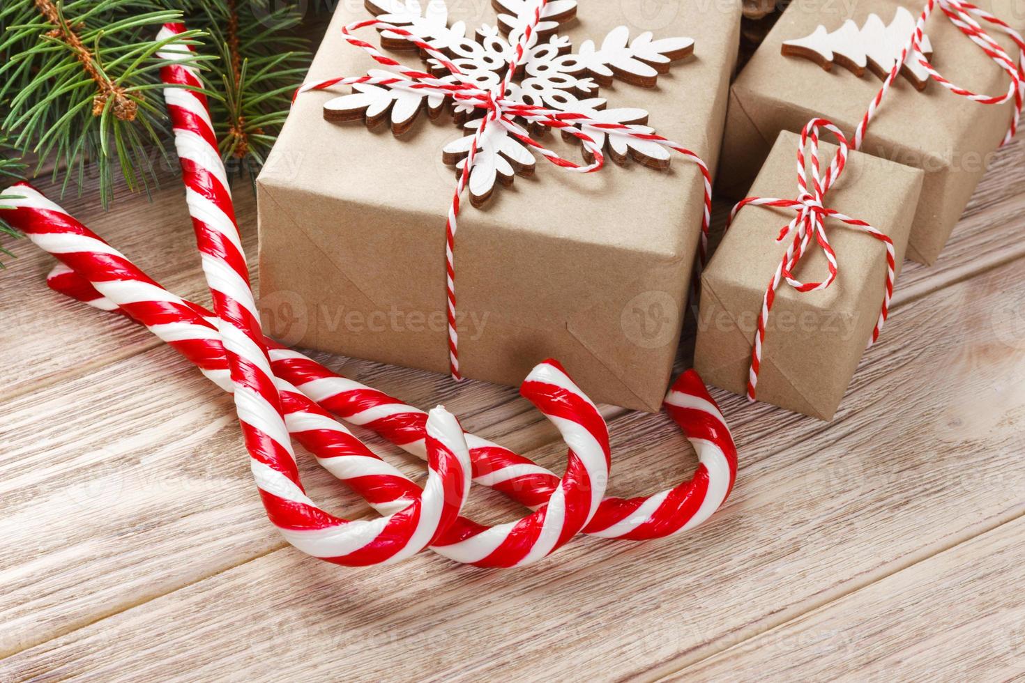 Christmas gift boxes and fir tree branch on wooden table. Top view with copy space photo