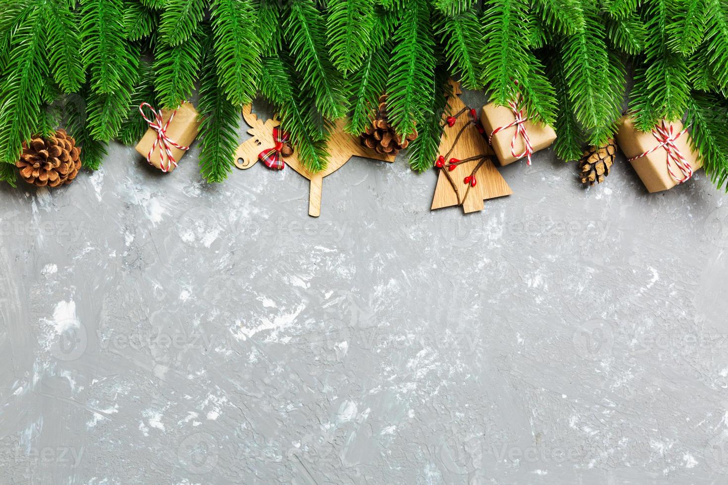 Top view of Christmas background made of fir tree and decorations on cement background. New year holiday concept with copy space photo