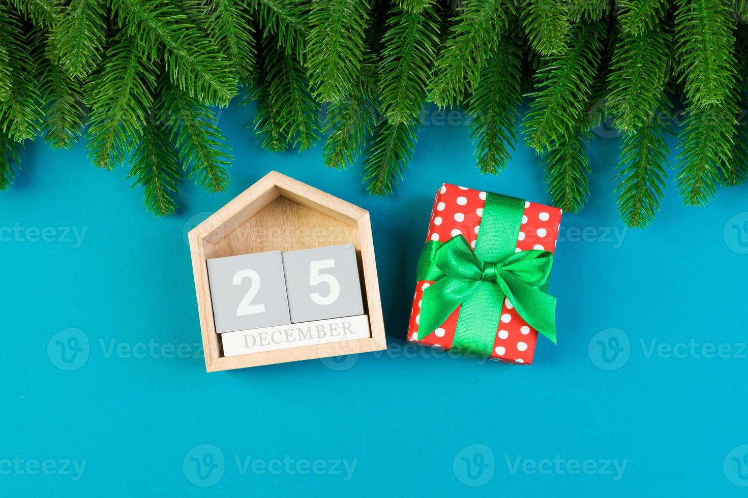 vista superior del abeto, calendario de madera y caja de regalo sobre fondo colorido. el veinticinco de diciembre. feliz navidad con espacio vacío para tu diseño foto