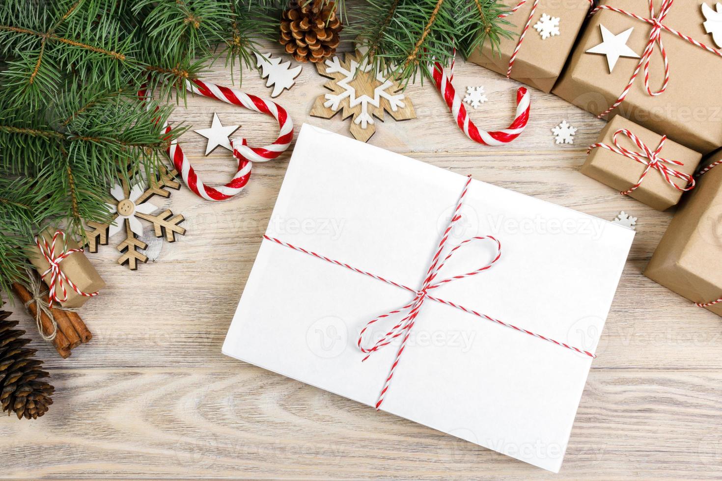 Parcel in Envelope with Fir-tree Branches and christmas decoration on a Wooden Background photo