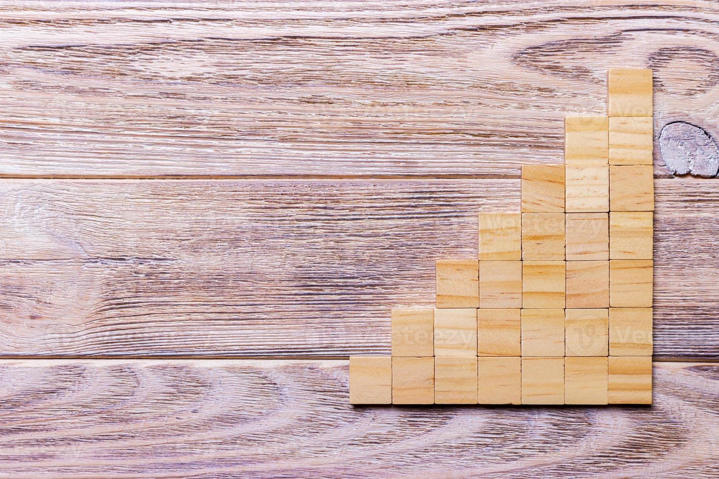 A wooden blocks cube over black wooden textured background with copy space for add word text title. Concept or conceptual Wood block stair or seven steps. Cubic photo