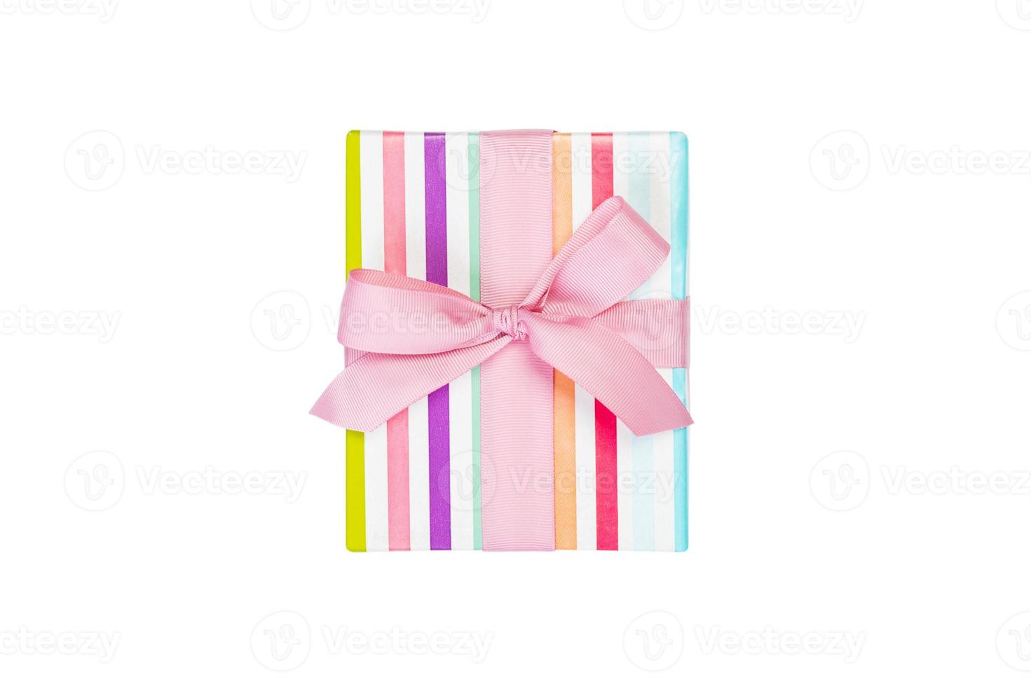 Christmas or other holiday handmade present in colored paper with pink ribbon. Isolated on white background, top view. thanksgiving Gift box concept photo