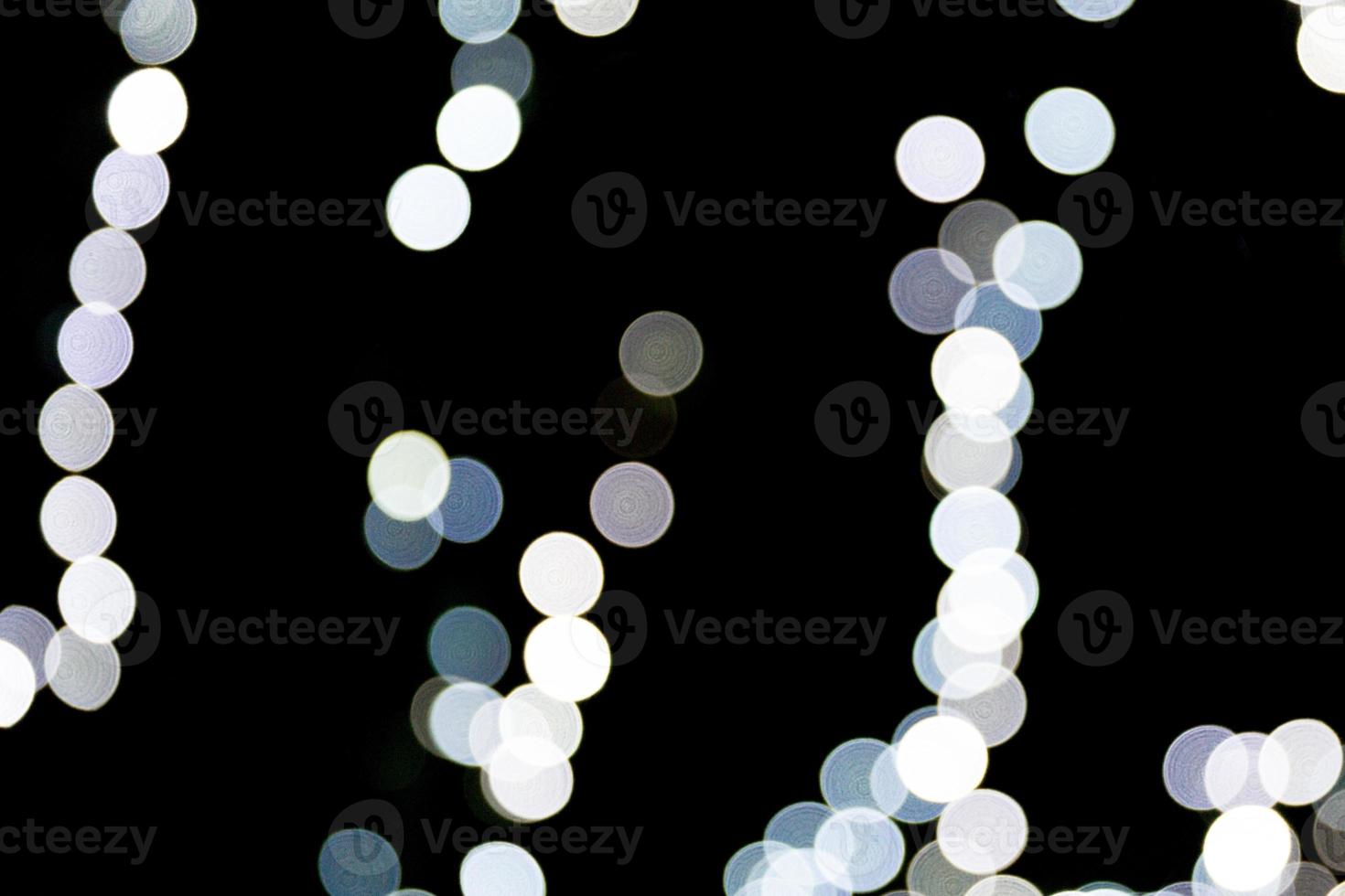 Unfocused abstract white bokeh on black background. defocused and blurred many round light photo