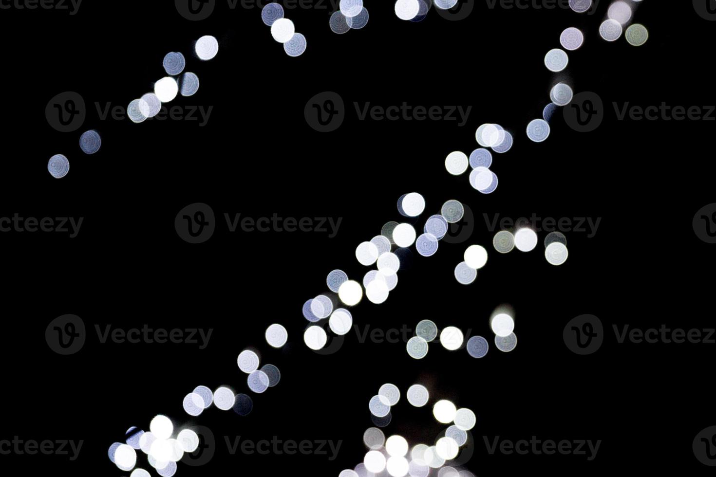 Abstract bokeh of white city lights on black background. defocused and blurred many round light photo