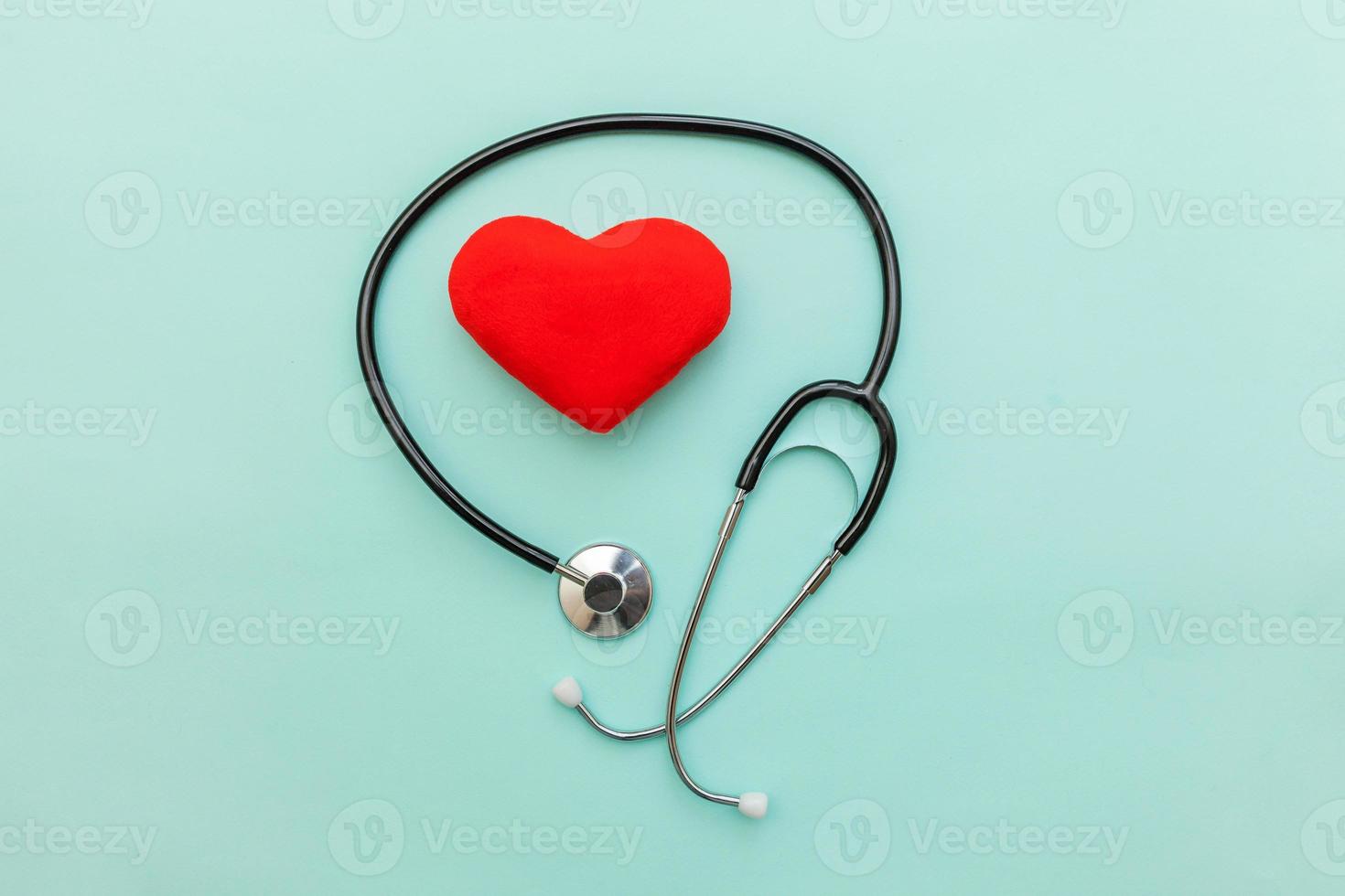 equipo de medicina estetoscopio o fonendoscopio y corazón rojo aislado en un moderno fondo azul pastel. dispositivo de instrumento para médico. concepto de seguro de vida de atención médica foto