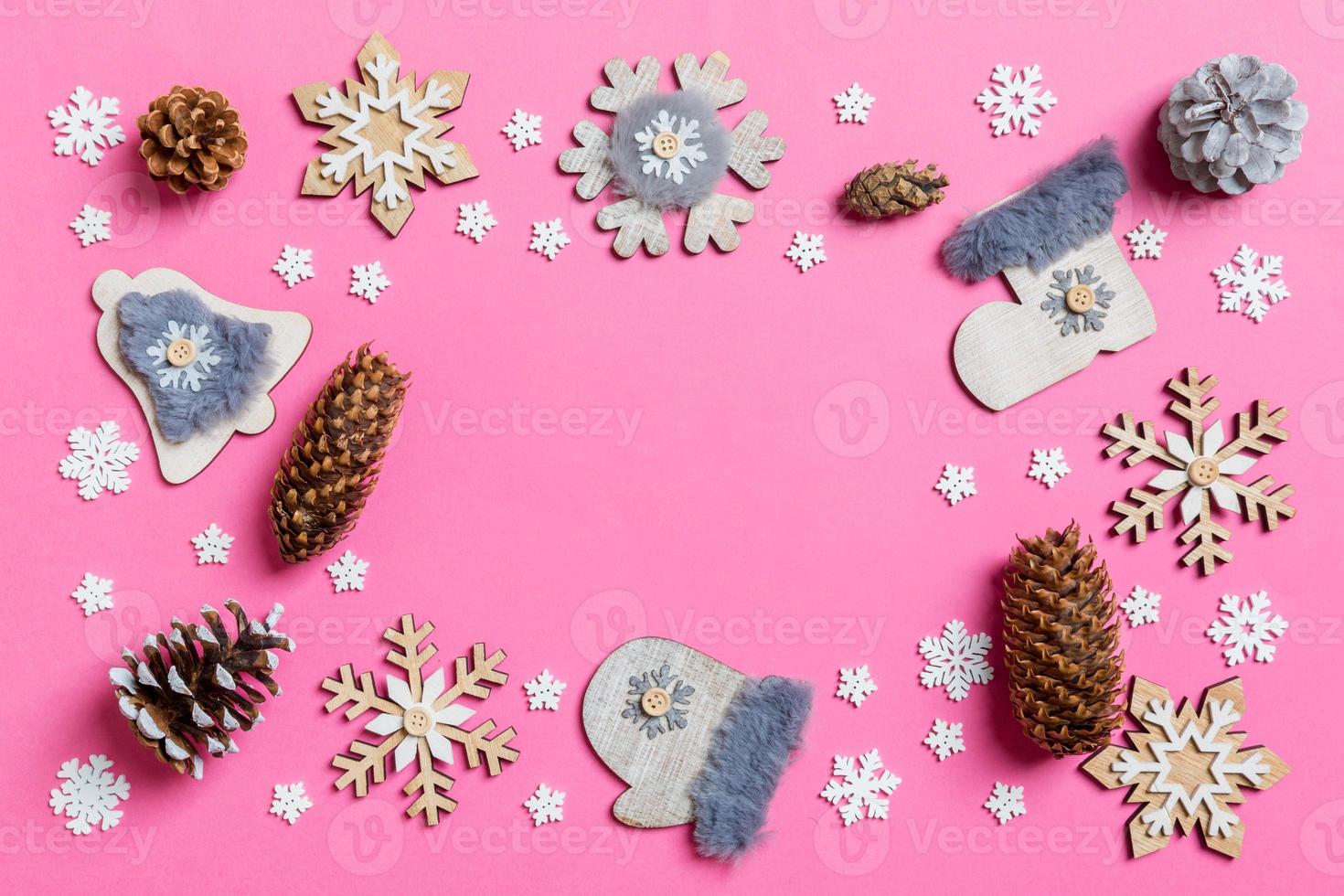 Top view of holiday toys and decorations on pink Christmas background. New Year time concept with copy space photo