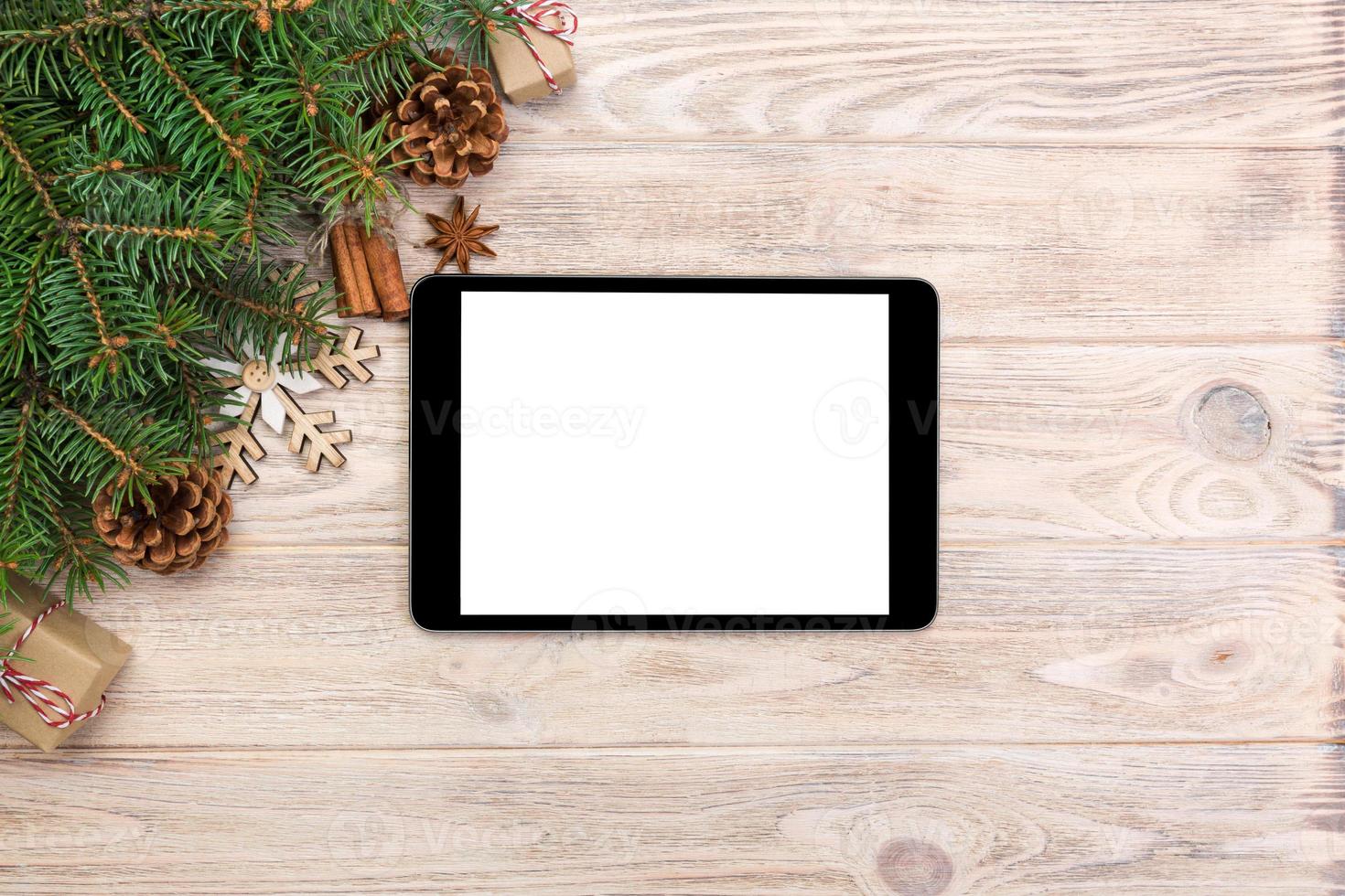 Digital tablet mock up with rustic Christmas wood background decorations for app presentation. top view with copy space photo