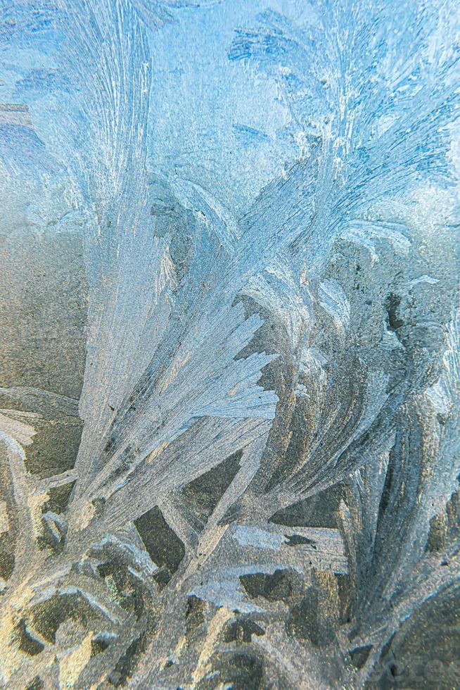 Frozen winter window with shiny ice frost pattern texture. Christmas wonder symbol, abstract background. Extreme north low temperature, natural Ice snow on frosty glass, cool winter weather outdoor. photo