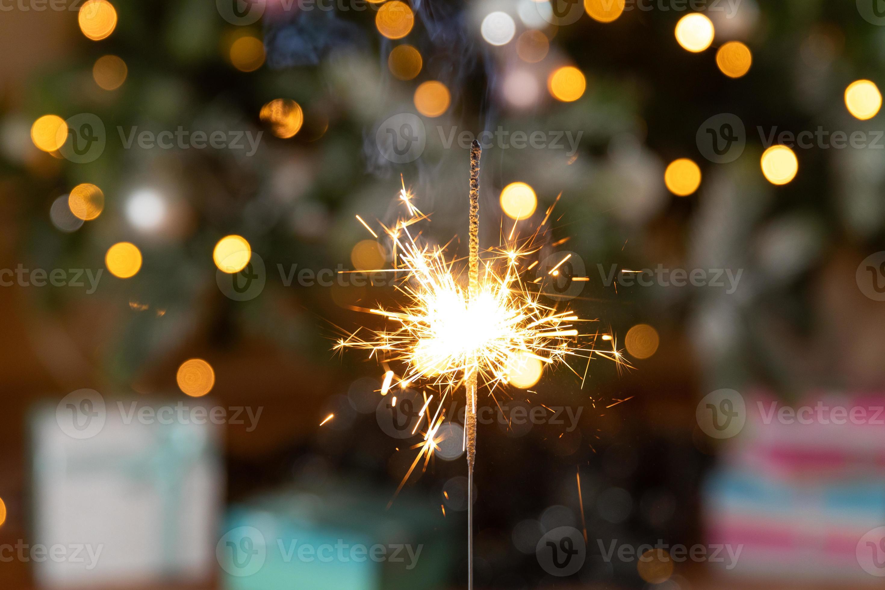 velas de bengalas brillantes de navidad se queman en el fondo del árbol de  navidad. decoración de iluminación navideña en el interior de la casa.  luces de chispas mágicas festivas para fiestas