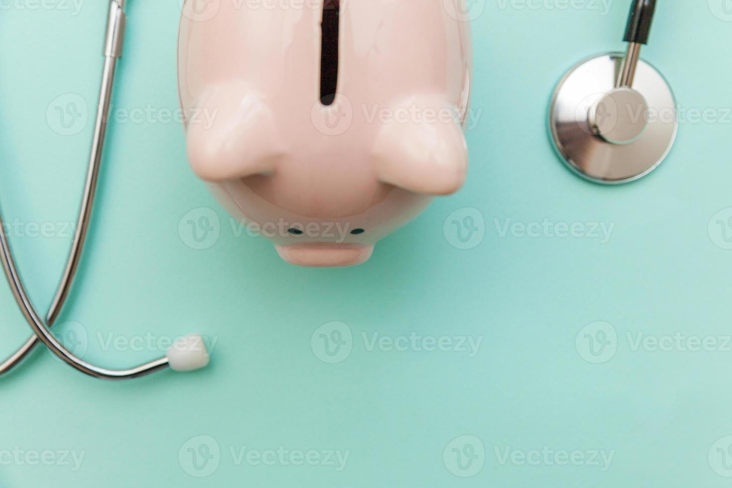 Medicine doctor equipment stethoscope or phonendoscope and piggy bank isolated on trendy pastel blue background photo