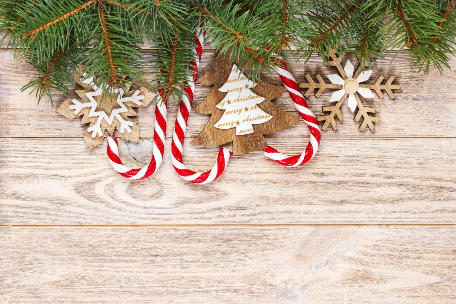 bastones de caramelo de navidad y copos de nieve sobre un fondo de madera foto