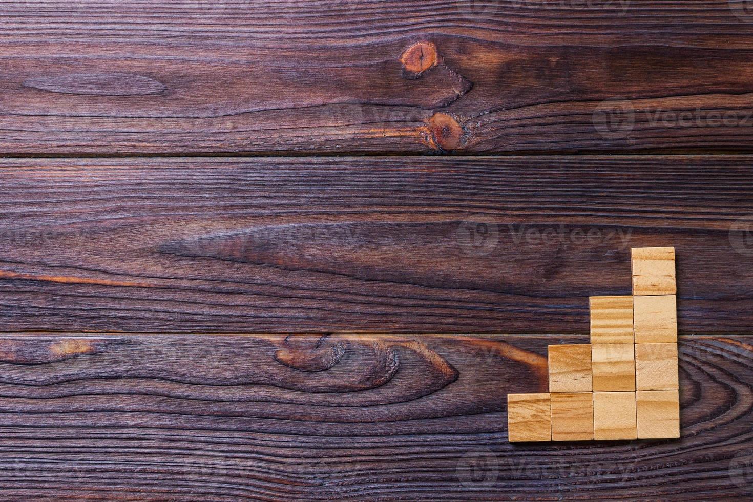 A wooden blocks cube over black wooden textured background with copy space for add word text title. Concept or conceptual Wood block stair or four steps. Cubic photo