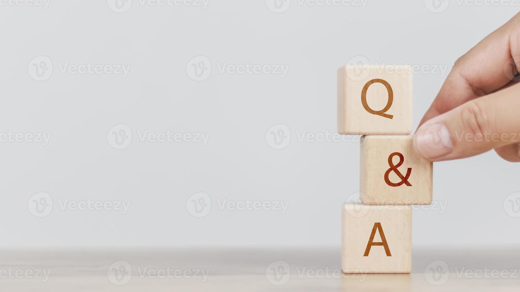 a man hand holding Q and A word with wooden cube block.Frequently asked questions, Business customer service and support photo