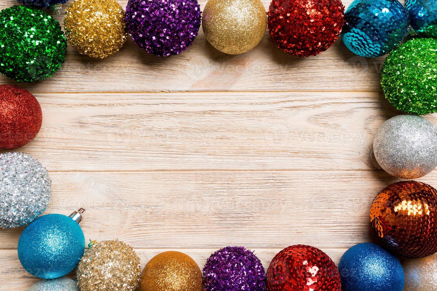 Top view of frame made of decorative balls on wooden background. Christmas toys concept with empty space for your design photo