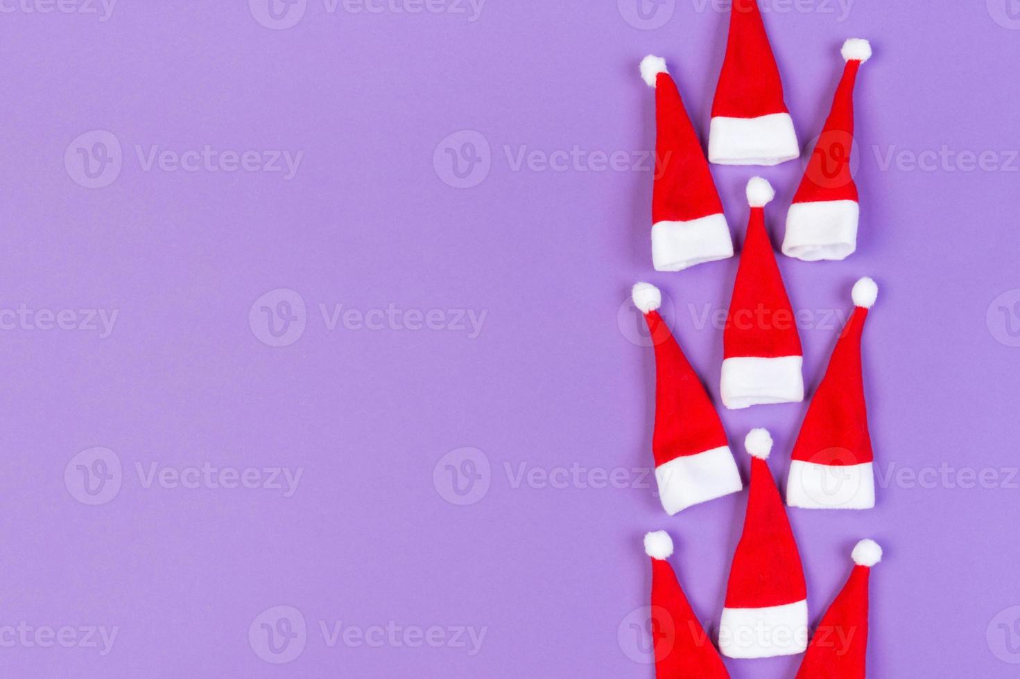 Top view od stylish red Santa hats on colorful background. Merry Christmas concept with copy space photo