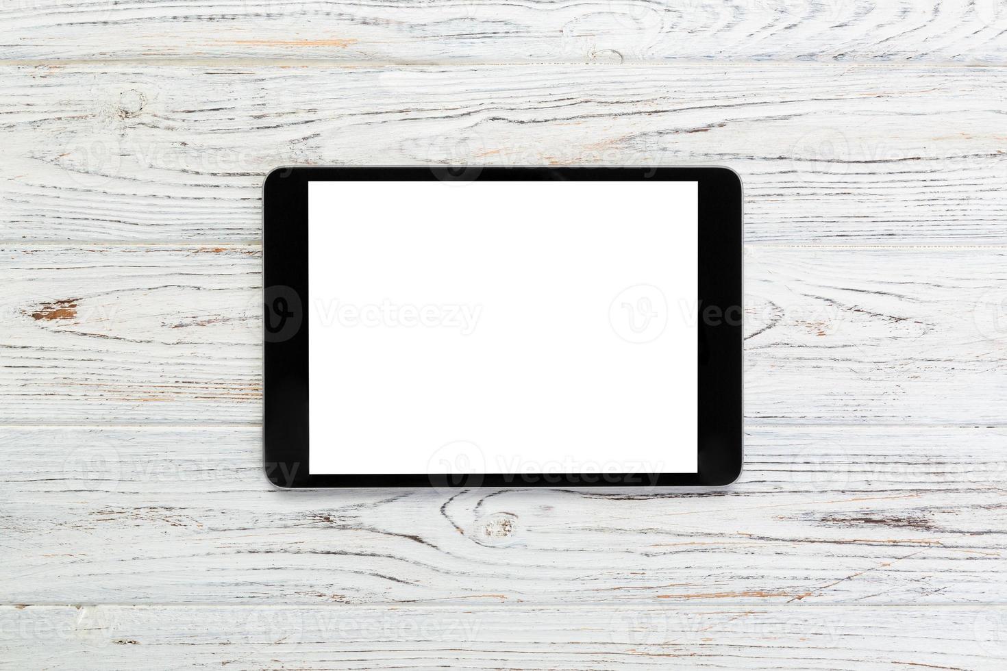 black digital tablet on rustic wooden table background. mock up top view photo