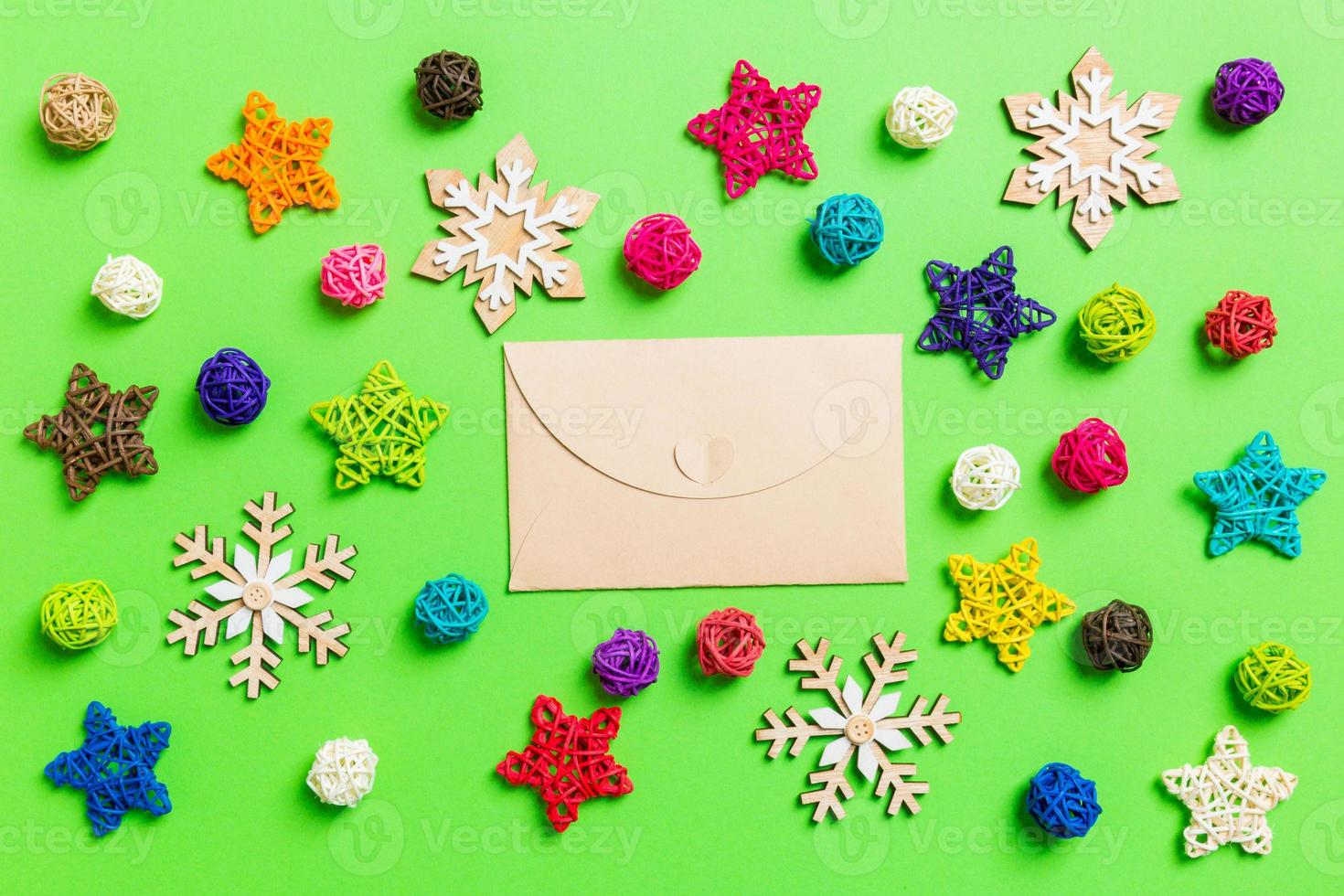 Top view of craft envelope. New Year decorations on green background. Festive stars and balls. Merry Christmas concept photo