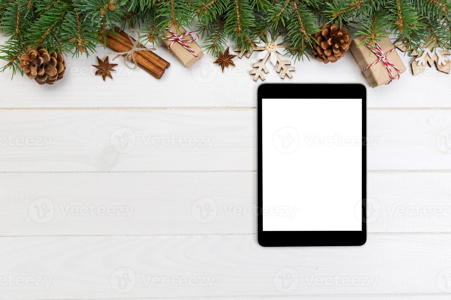 Digital tablet mock up with rustic Christmas wooden background decorations for app presentation. top view with copy space photo