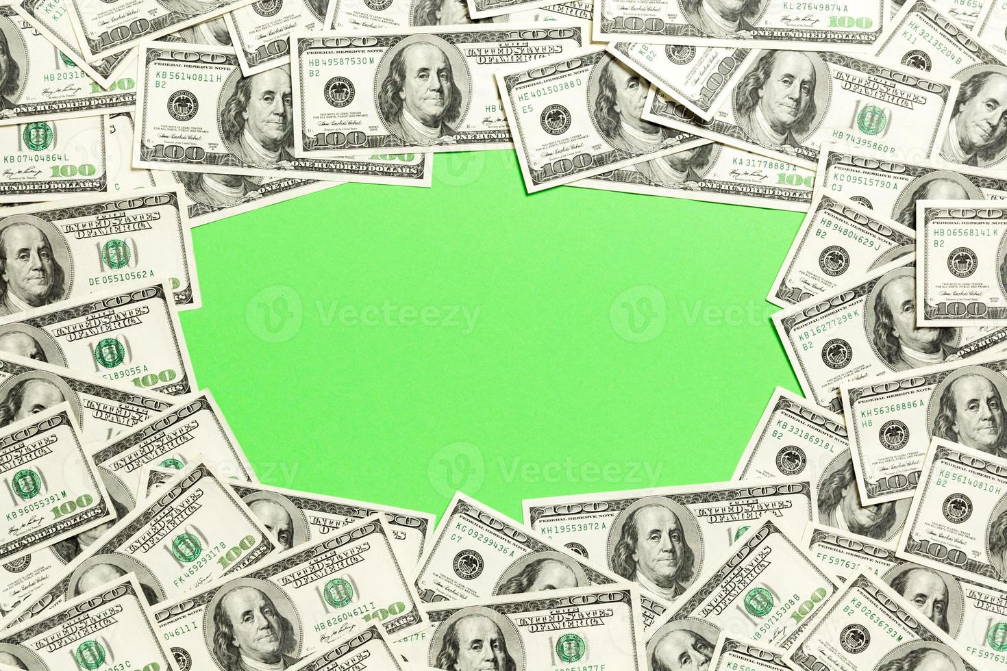 Frame of one hundred dollar bills with empty space for your design. Top view of business concept on green background with copy space photo