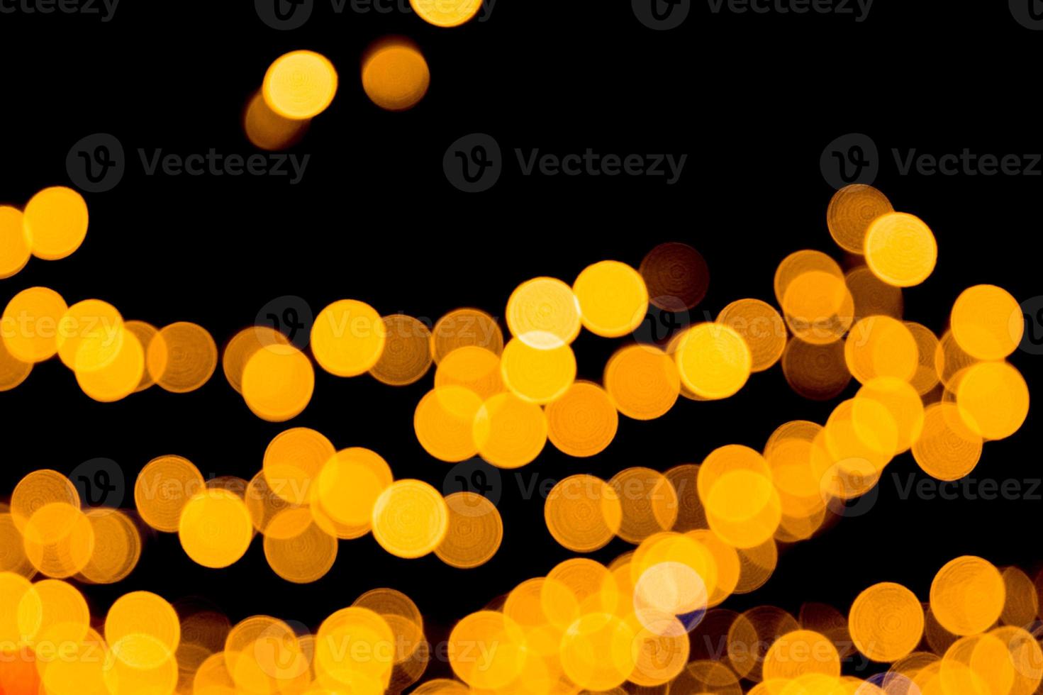 Unfocused abstract yellow bokeh on black background. defocused and blurred many round light photo