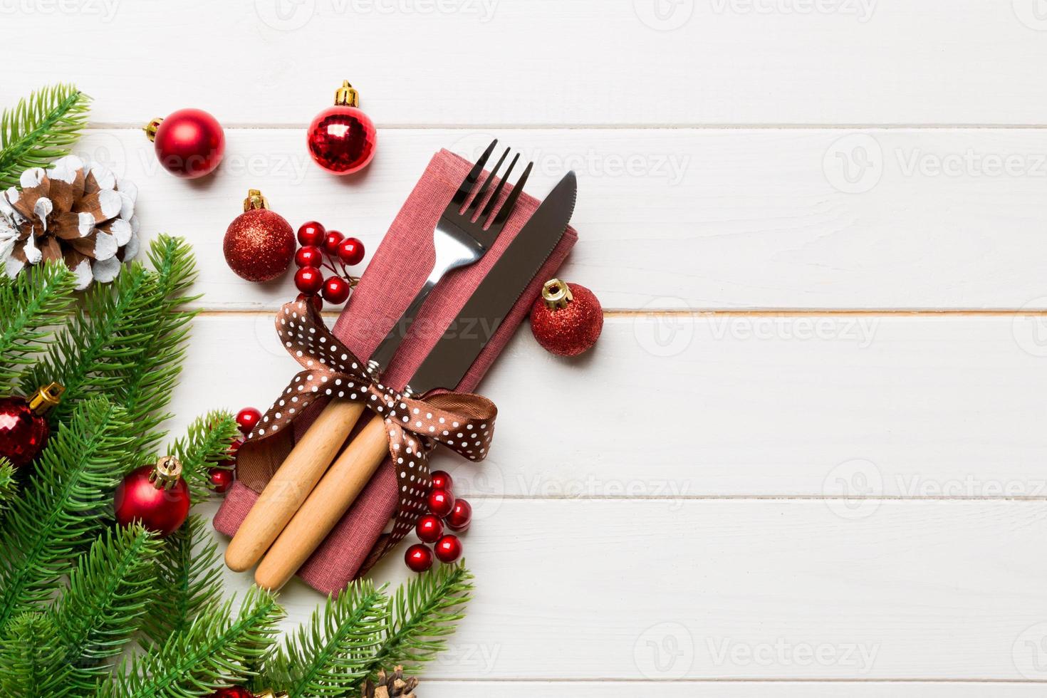 Top view of festive cutlery on new year wooden background. Christmas decorations with empty space for your design. Holiday dinner concept photo
