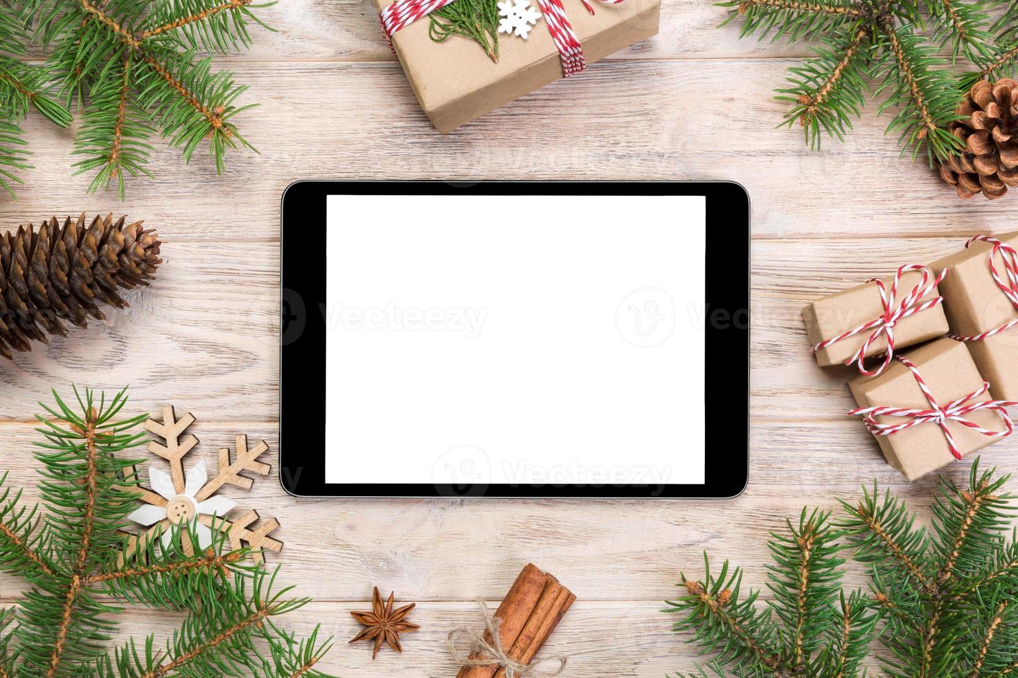 Digital tablet mock up with rustic Christmas wood background decorations for app presentation. top view with copy space photo