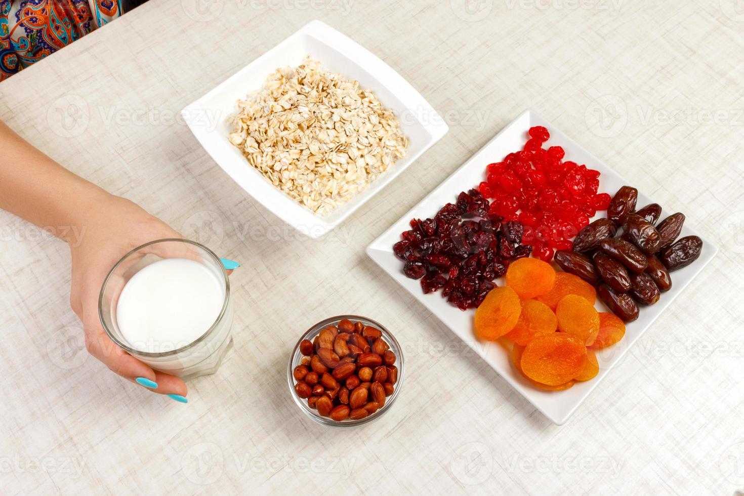 la niña tomó leche para verterla en avena. desayuno útil y saludable. Fondo blanco foto