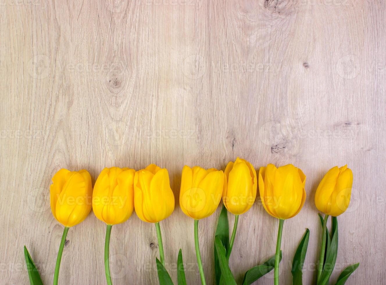 Yellow tulips on a wooden table, easter background photo