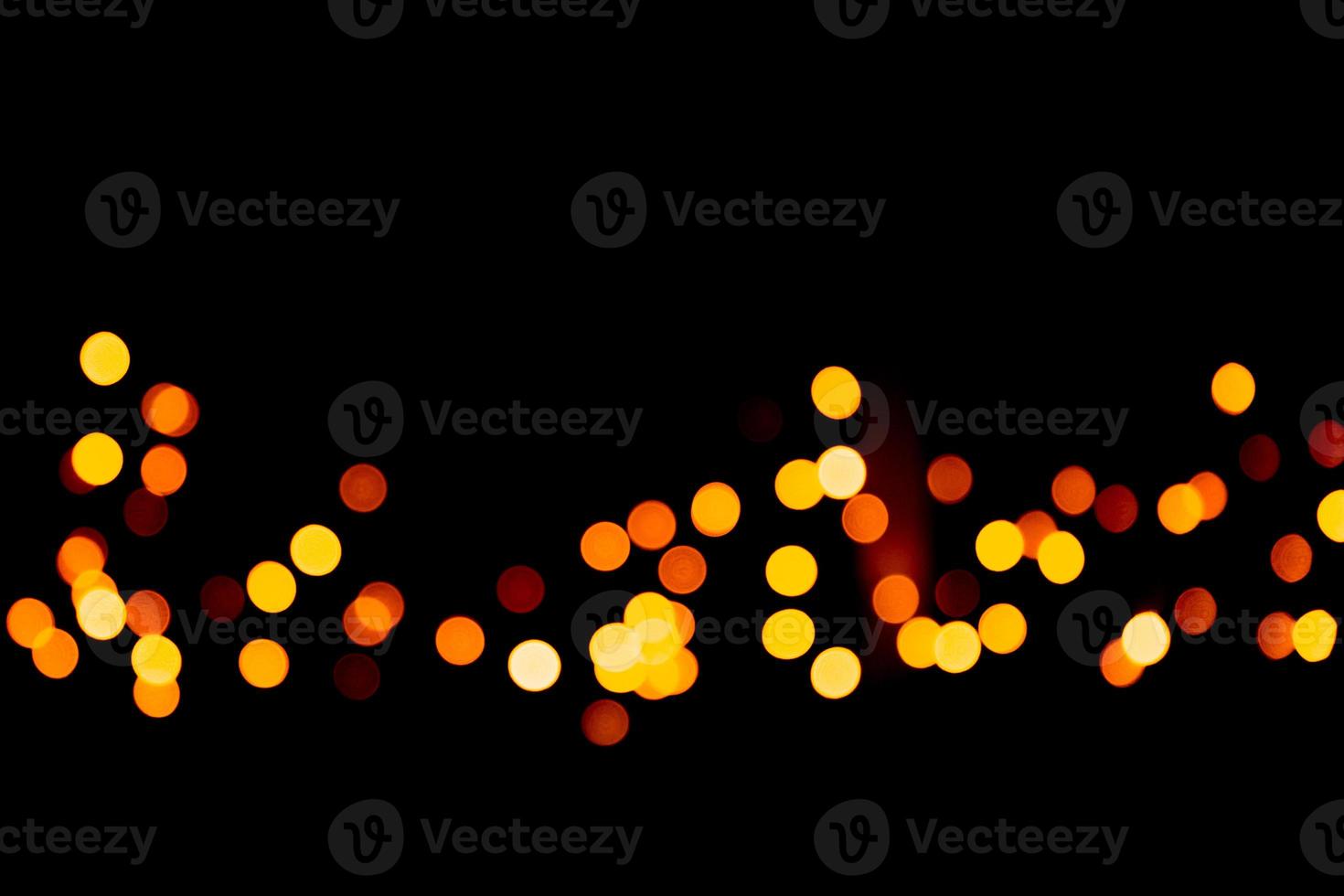Unfocused abstract gold bokeh on black background. defocused and blurred many round light photo