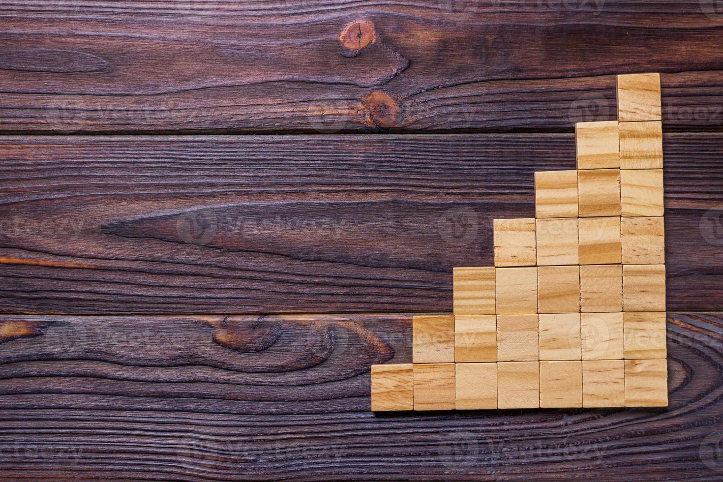 A wooden blocks cube over black wooden textured background with copy space for add word text title. Concept or conceptual Wood block stair or seven steps. Cubic photo