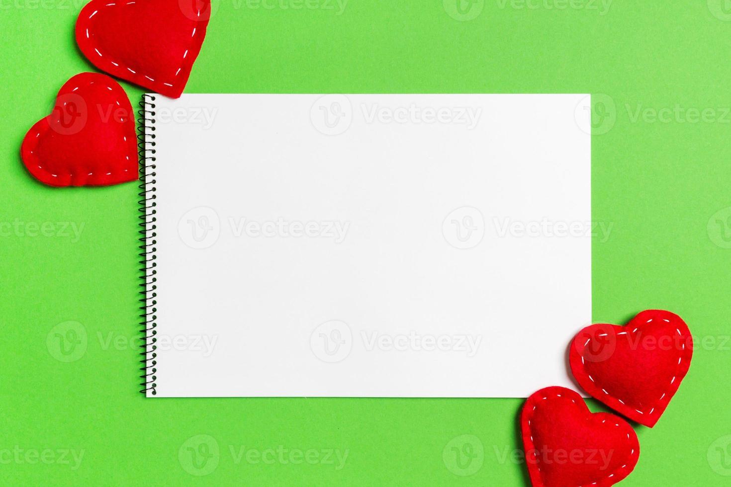 Top view of notebook surrounded with hearts on colorful background. Valentine's day photo