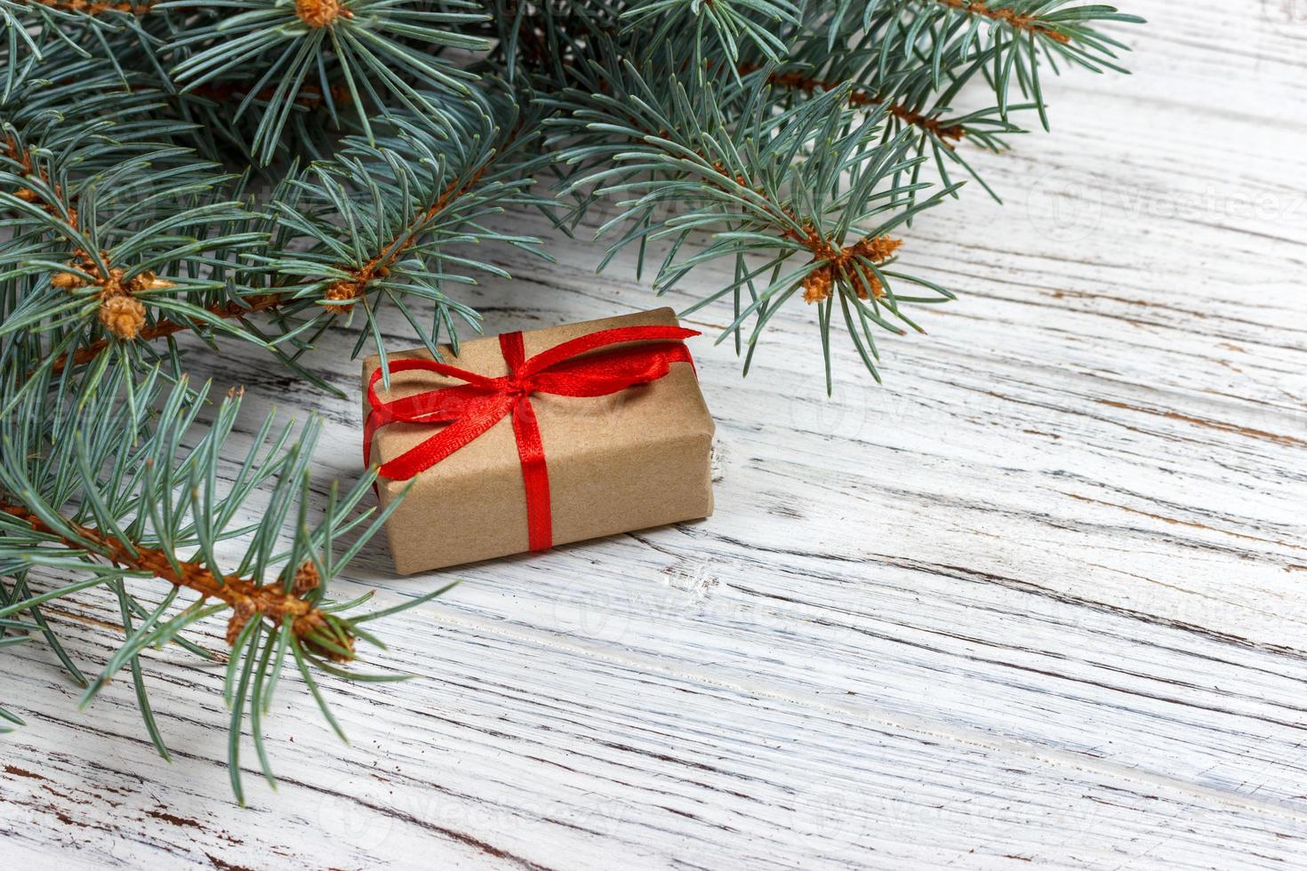 Christmas gift boxes and fir tree branch on wooden table. Top view with copy space photo