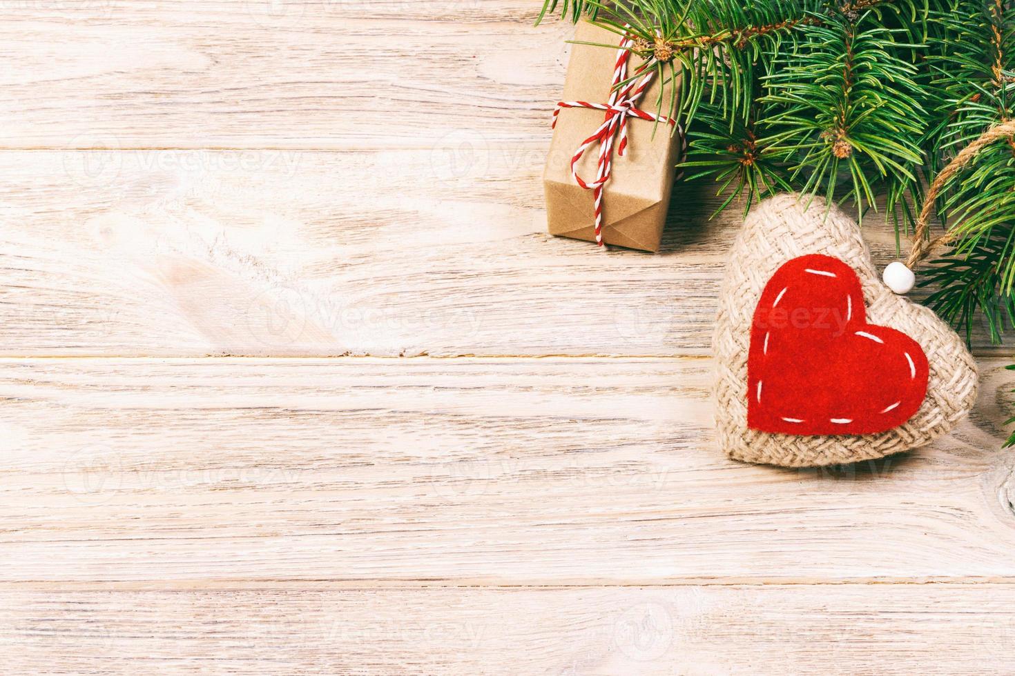 Christmas background with fir branches, knitted heart and gift boxes on white wooden table. Christmas background. Flat lay. top view with copy space. Toned photo