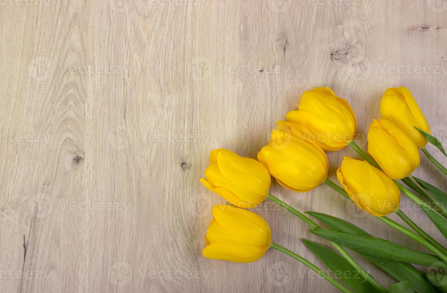 tulipanes amarillos sobre una mesa de madera, fondo de Pascua foto