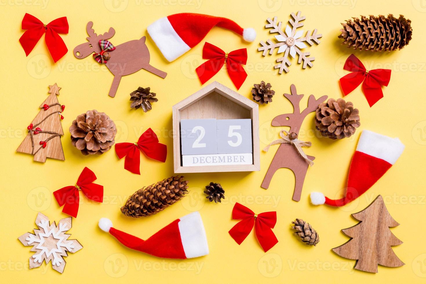 Christmas yellow background with holiday toys and decorations. Top view of wooden calendar. The twenty fifth of December. Merry Christmas concept photo