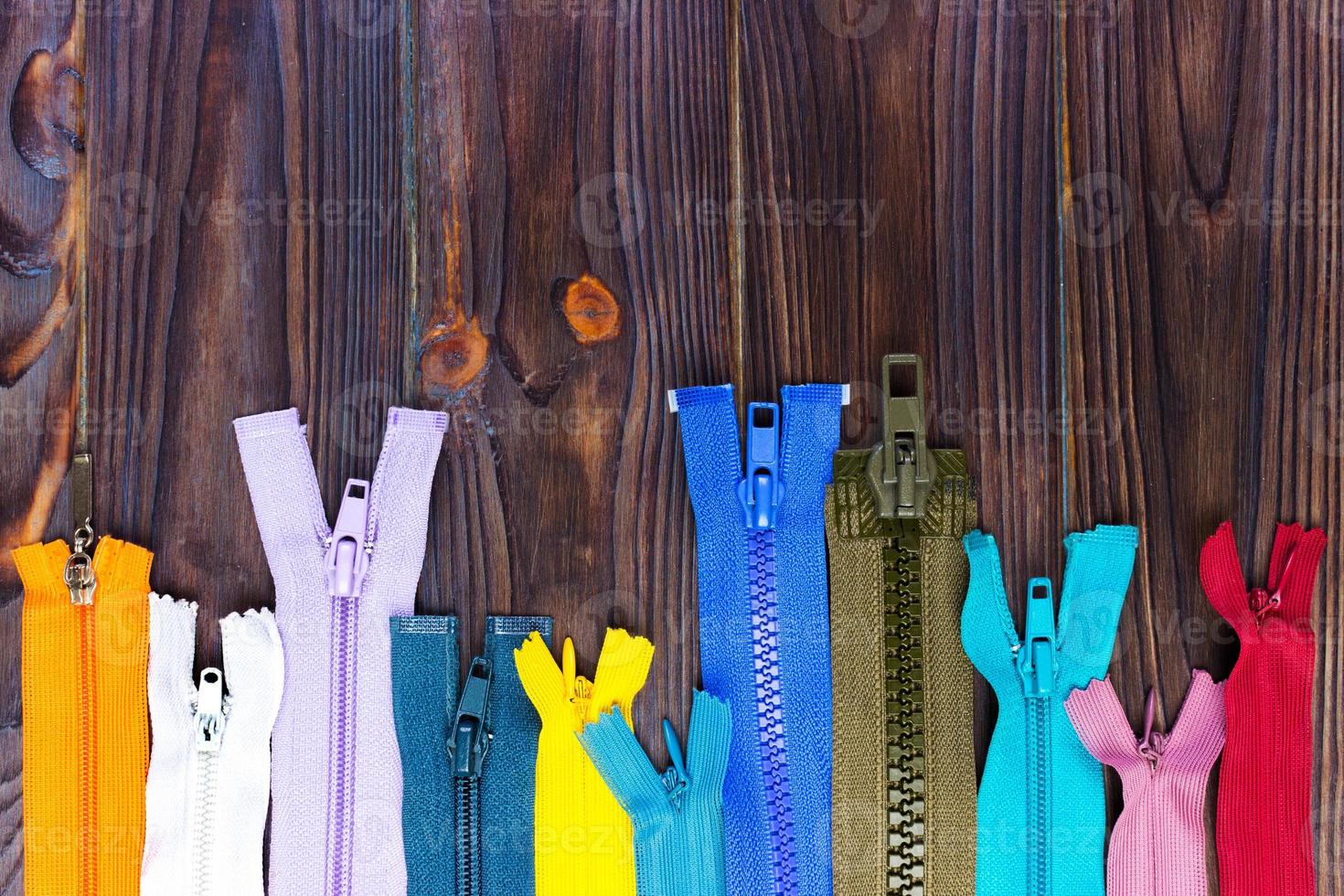 las cremalleras multicolores se colocan sobre una mesa de madera foto