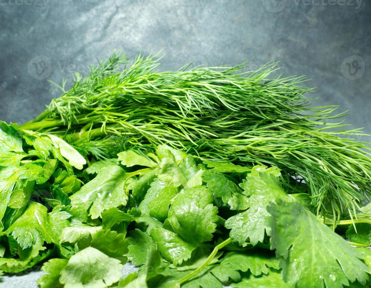 Mix of greens from the garden. Parsley, cilantro, dill on the kitchen table.  Useful food. Spices for the dish. Salad preparation. Green coriander. photo