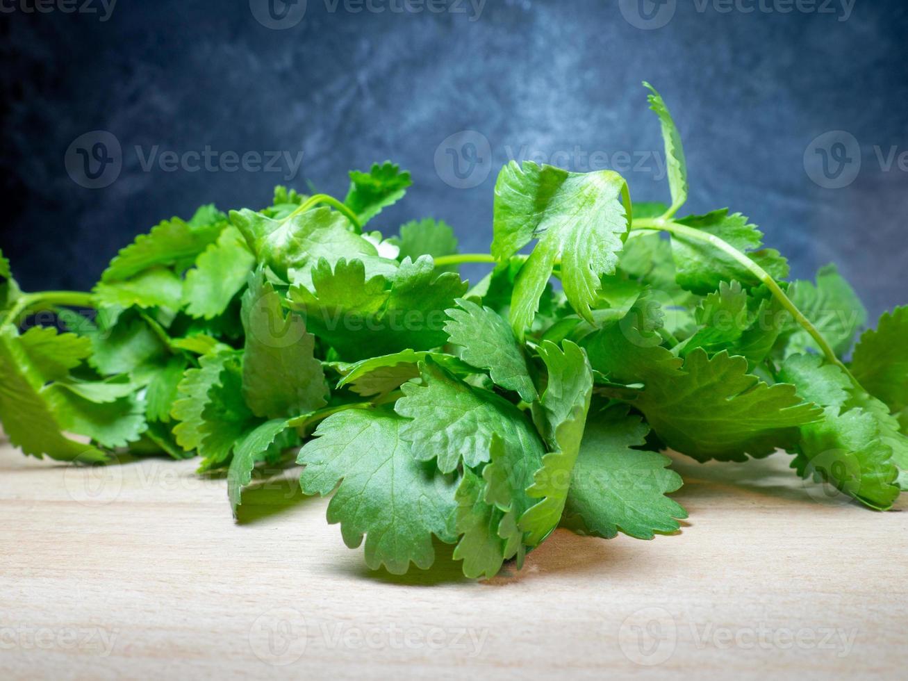 Parsley on the table. Useful product. Greens on a cutting board. Vegetarian lunch ingredient. Lots of parsley stalks. photo