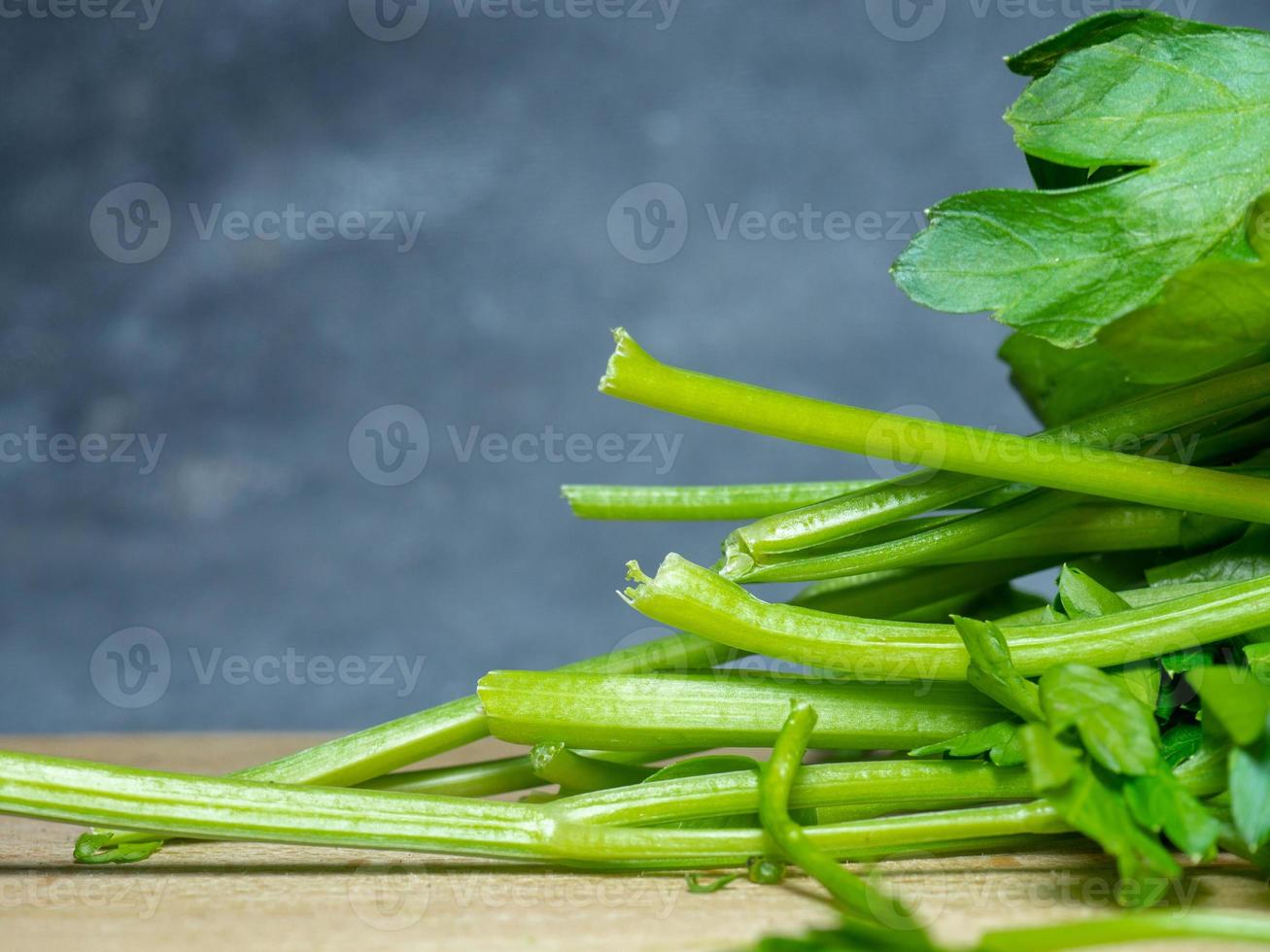 Parsley on the table. Useful product. Greens on a cutting board. Vegetarian lunch ingredient. Lots of parsley stalks. photo