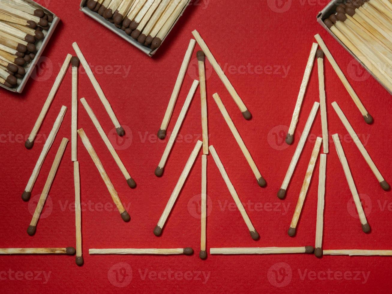 Matches on a red background. Safe handling of fire. Fire dangers. Lots of matches.  Pictures lined with matches. Trees of matches photo