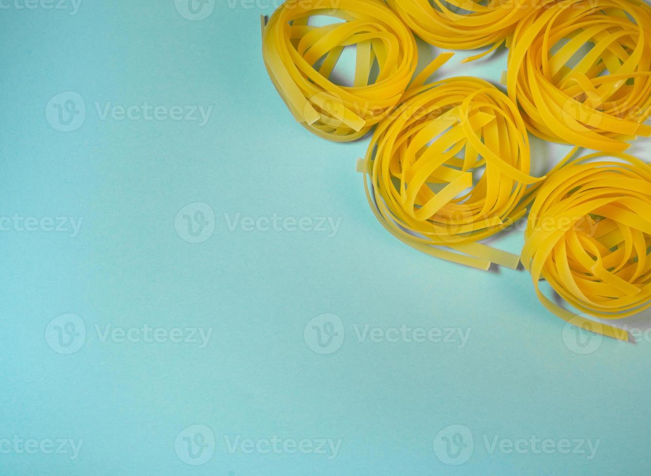 Pasta nest on a blue background. Noodle type. Culinary background. Background from noodles.Pasta on the table. Unprepared product. Cooking. photo