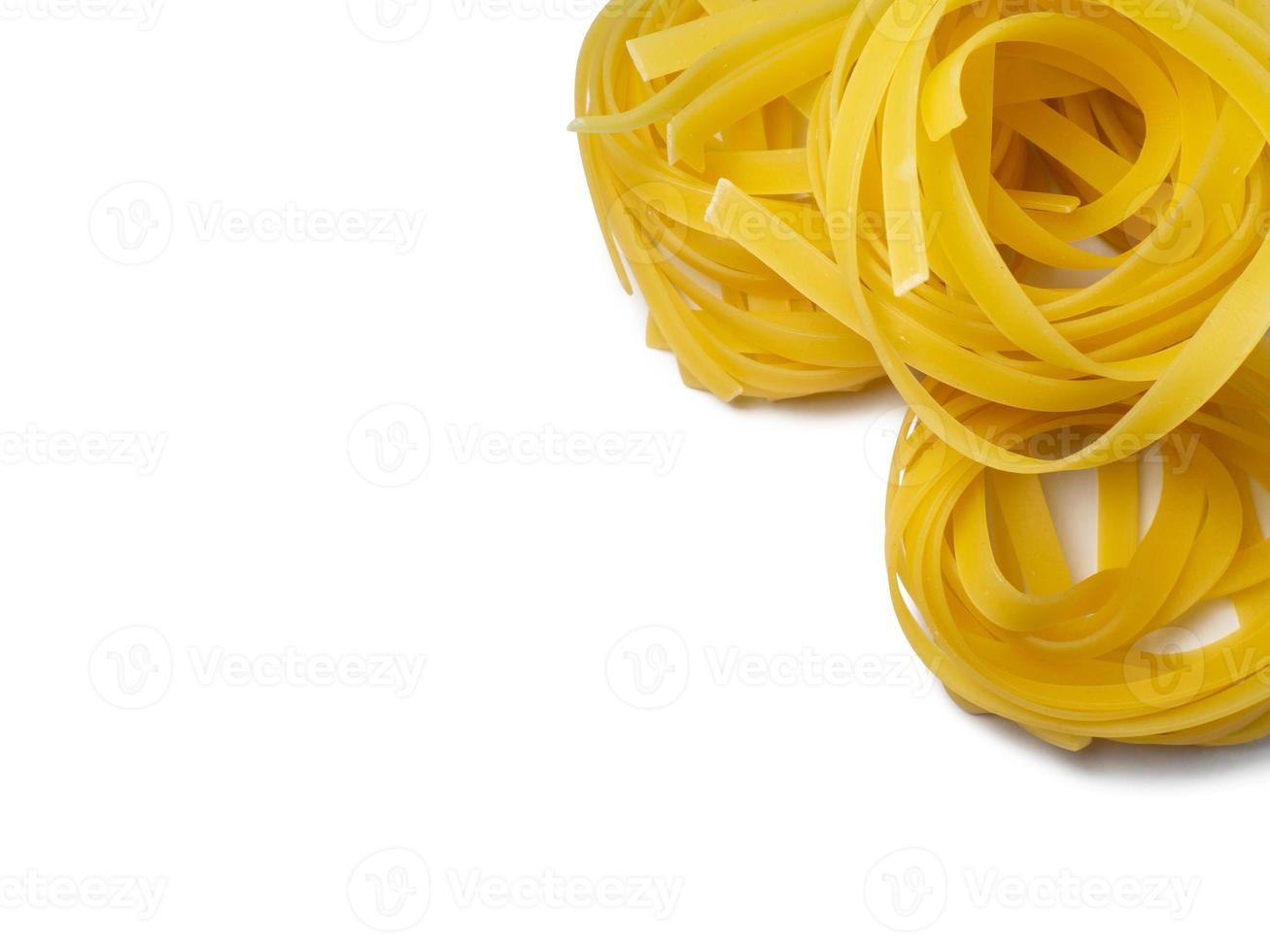 Pasta nests on a white background. Culinary background. Curled pasta on the table. Uncooked product.  Product made from flour and dough. Background from noodles. photo