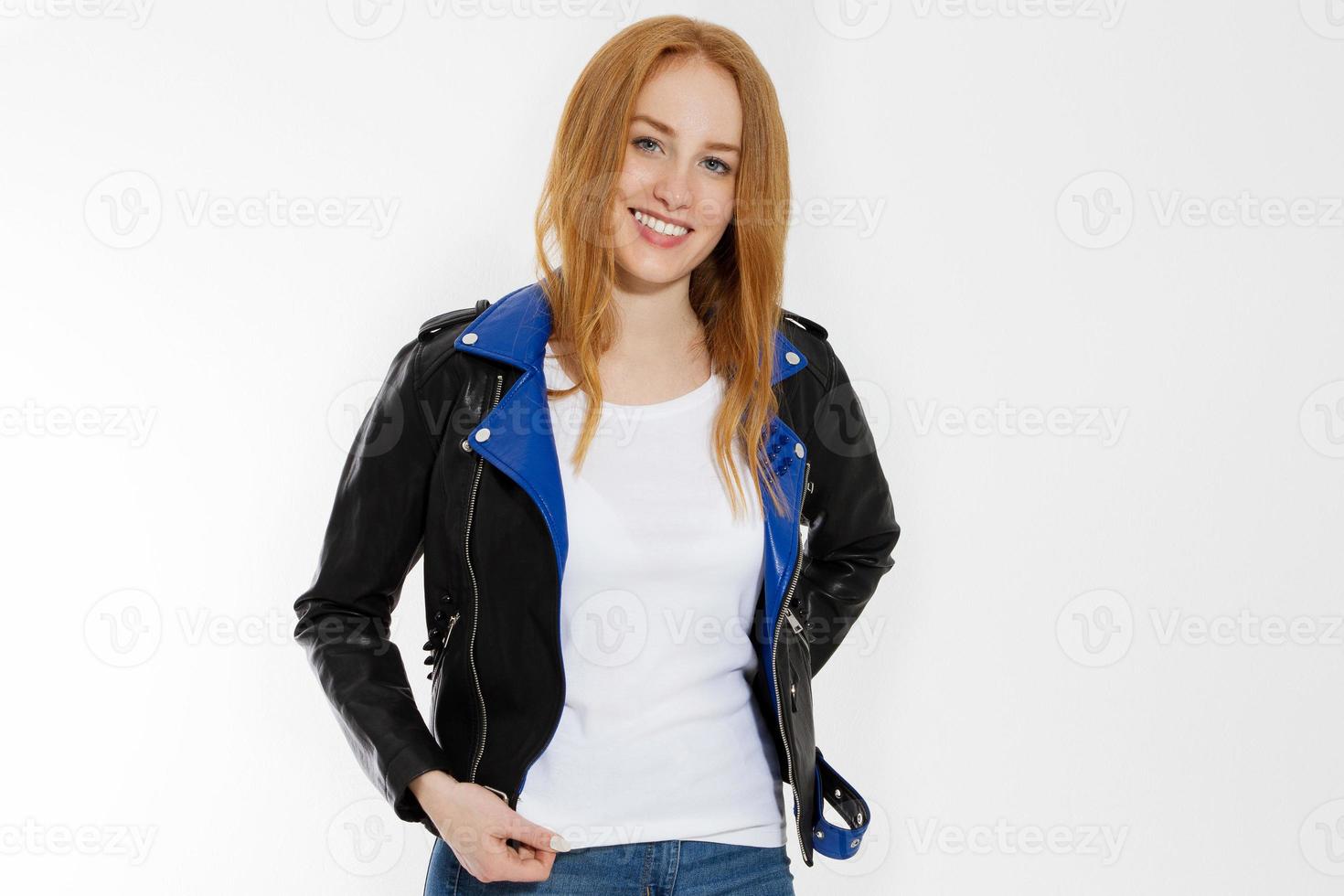 feliz joven emocionada con camiseta blanca y chaqueta de cuero negro aislada de fondo blanco. chica de pelo rojo en la vista frontal de la ropa de moda. camiseta de verano de plantilla en blanco. copie el espacio foto