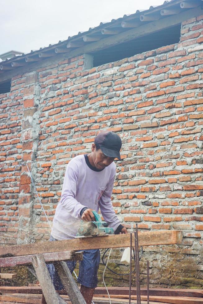 tegal, jawa tengah, 2022 - trabajadores de la construcción afeitando madera con máquina para fundición foto