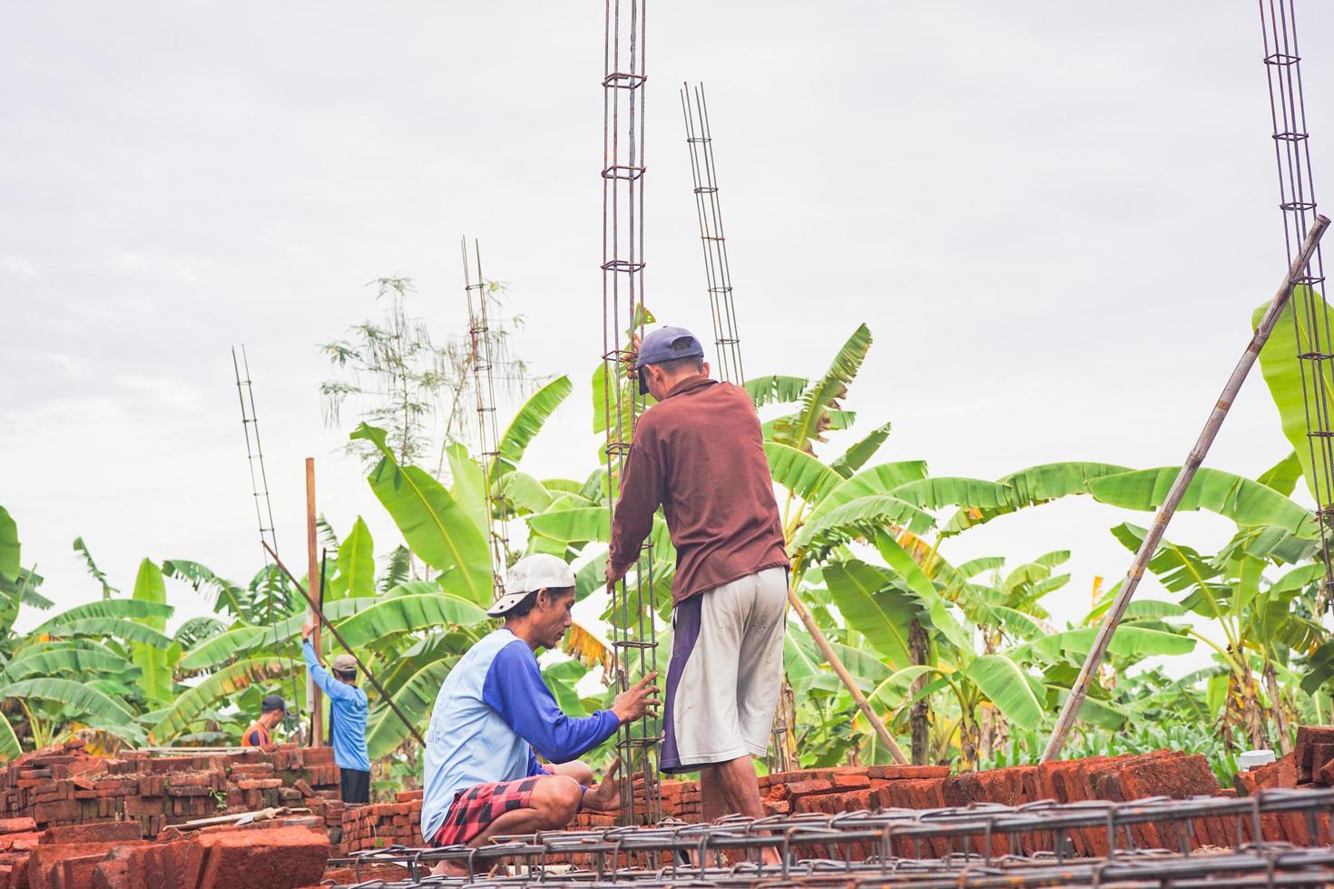 dos trabajadores de la construcción instalan hierro fundido para construir las paredes. la construcción de viviendas foto