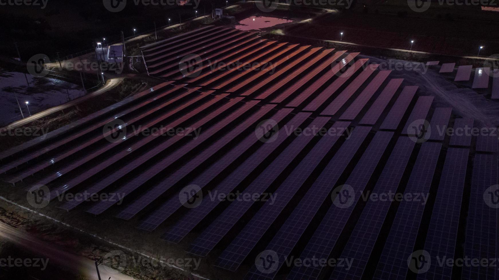 Aerial view of a solar farm producing clean energy during the evening with twilight and visible all around area photo