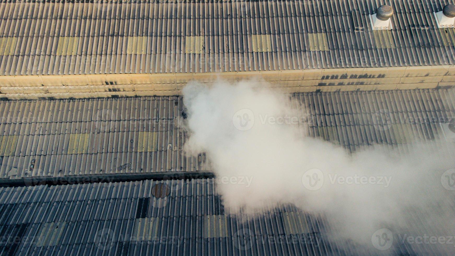 Toxic fumes spread from the roof of an industrial plant. Industrial
